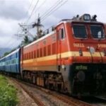 रेलवे स्टेशन पर समर स्पेशल ट्रेन का इंतजार करते यात्री और प्लेटफॉर्म पर खड़ी ट्रेन।