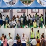 जन कल्याण शिविर में बैठे अधिकारी और अपनी समस्याएं बताते लोग।