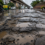 बारिश के बाद गड्ढों और जलभराव से खराब हुई दिल्ली की सड़क का दृश्य।